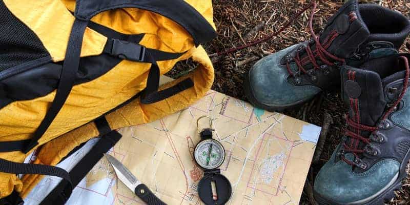 backpack map compass and hiking boots for bugging out