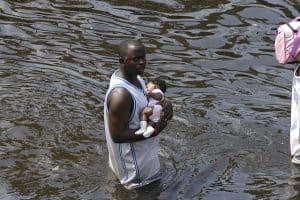 Unprepared father taking infant out in flood water