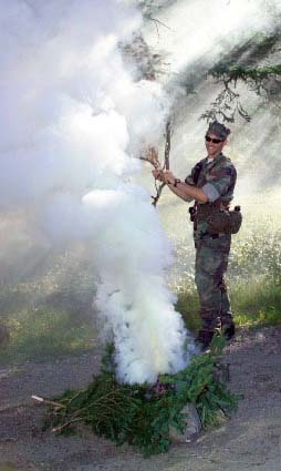 Soldier practices making a smoke signal