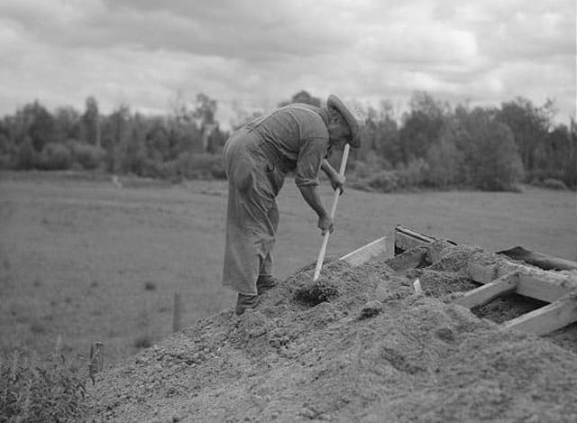 old photo of man burying the top of root cellar