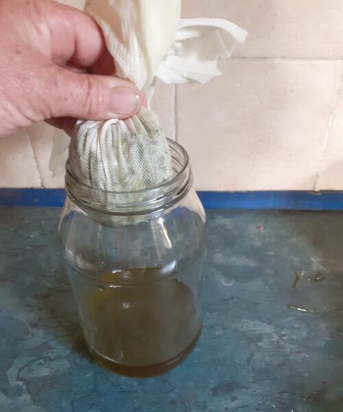 Straining Rosemary in a jar