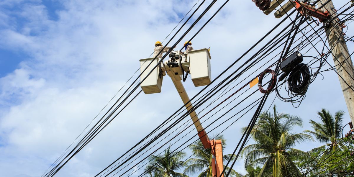 Electrician stays on the tower pole and repairs a wire