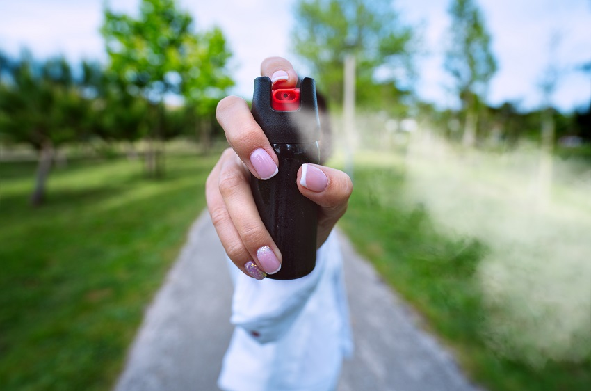 Woman using pepper spray for self defence. 