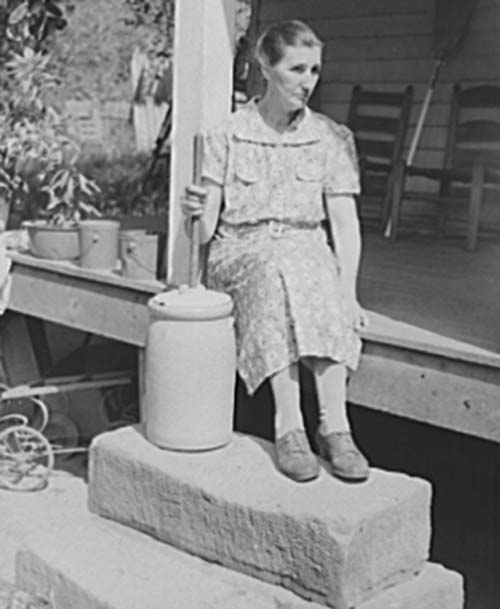 woman churning butter in early 1900s